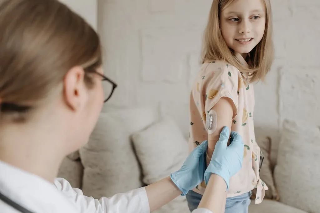 A doctor checking on a child with a diabetes device on her right arm.