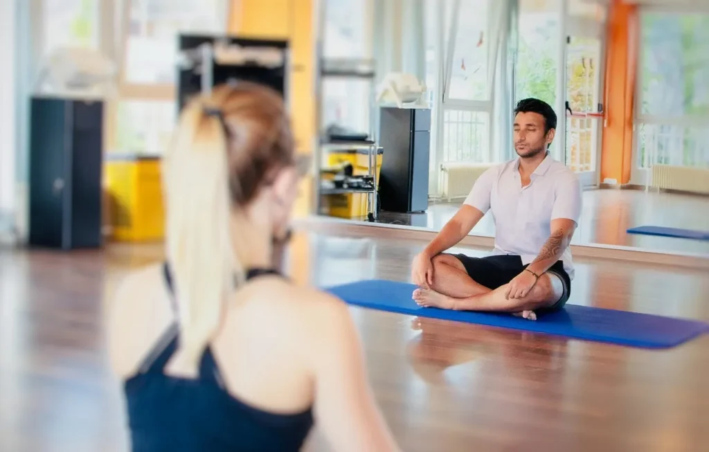 Man and woman in lotus position doing yoga meditation.
