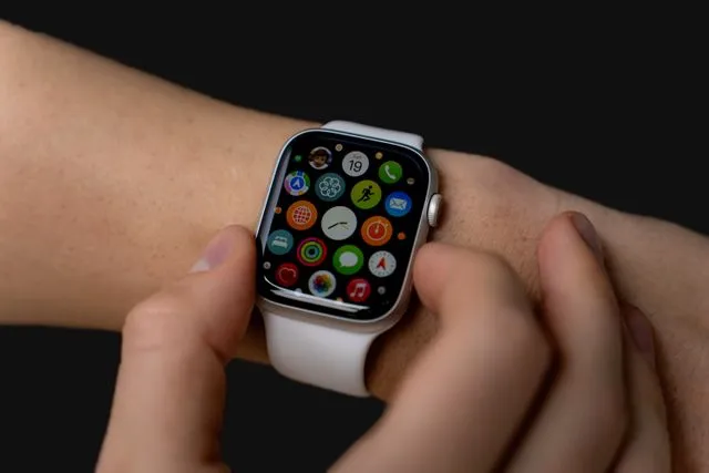 Close-up of a person interacting with a smartwatch on their wrist.